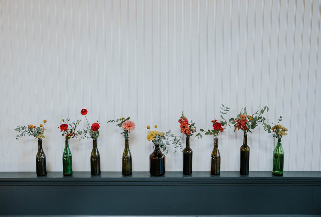 Bottles with red, orange, and pink flowers
