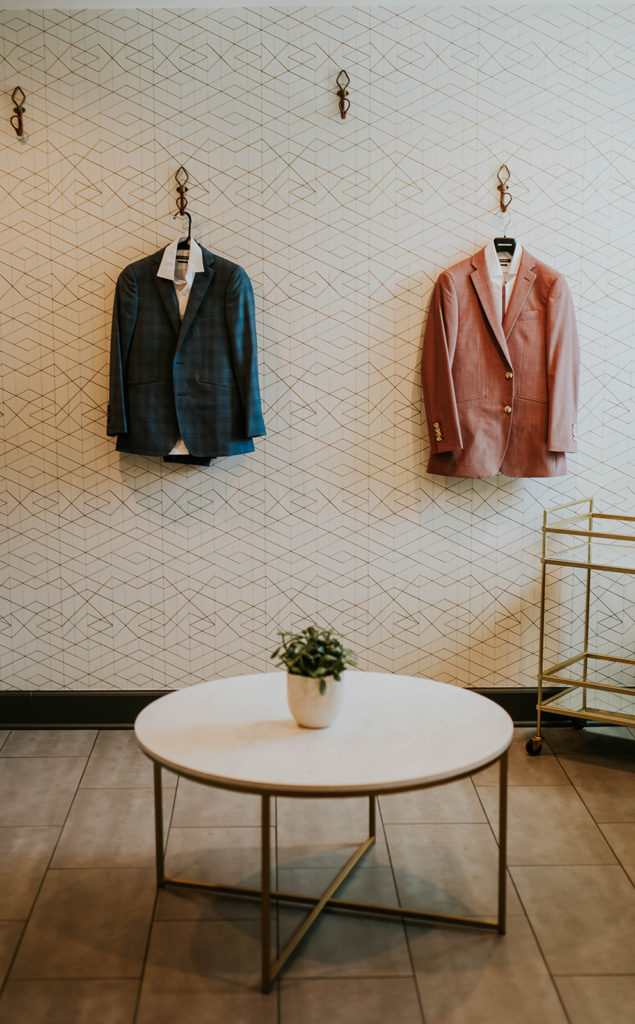 Blue suit jacket and pink suit jacket hanging on a wall